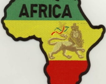 May include: An embroidered patch shaped like the continent of Africa. The patch is green, yellow, and red, with a lion in the center. The word "AFRICA" is embroidered in black letters across the top of the patch.