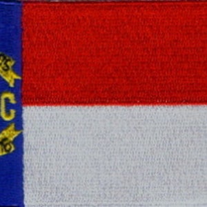 May include: A blue patch with a gold star and the letters "N.C." surrounded by a gold wreath with the words "May 20th 1775" and "April 12th 1776" on it. The patch is next to a red and white striped flag.