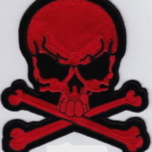 May include: Embroidered patch featuring a red skull with crossed bones, outlined in black. The skull has black eye sockets and a detailed design. The patch is likely for clothing or accessories.