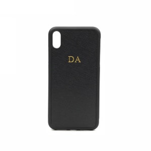May include: Black phone case with a textured finish and gold initials "DA" embossed on the back.