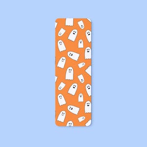 May include: A rectangular bookmark with rounded corners, featuring a repeating pattern of white cartoon ghosts with smiling faces on an orange background. The bookmark is set against a light blue backdrop.