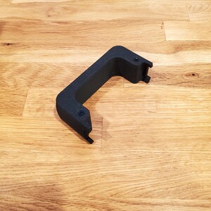 May include: Black plastic handle with a textured surface and two small screw holes.