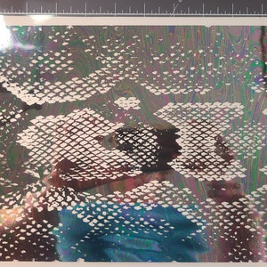 May include: A white snakeskin pattern on a iridescent background with shades of blue, green, and purple.