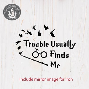 Puede incluir: Diseño gráfico en blanco y negro con el texto "Trouble Usually Finds Me", un par de gafas y una varita mágica. También hay varios pájaros pequeños volando alrededor del texto.