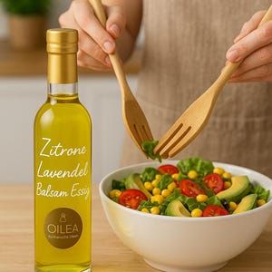 May include: A glass bottle of lemon and lavender balsamic vinegar with a gold cap and label. The label reads "Zitrone Lavendel Balsam Essig" and "Oilea Kulinarische Ideen".