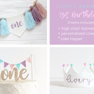 May include: A set of three Little Mermaid themed first birthday party decorations. The set includes a high chair banner with the word "one" in purple, a personalized crown with the name "Avery" in purple, and a cake topper with the word "one" in brown with a banner of pastel pink and blue triangles.