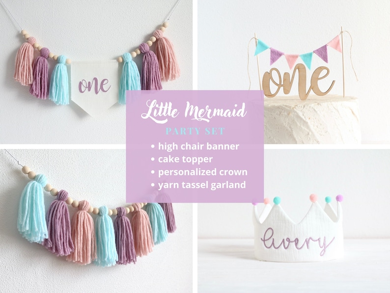 May include: A Little Mermaid themed first birthday party set with a pink and blue yarn tassel garland, a cake topper with a wooden "one" and a pink and blue bunting, and a white crown with the name "lavery" embroidered in purple.