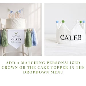 May include: A white cake with a "one" cake topper and a banner that reads "Caleb's hole in one." A white crown with the name "CALEB" is also shown. The image also includes the text: "ADD A MATCHING PERSONALIZED CROWN OR THE CAKE TOPPER IN THE DROPDOWN MENU."