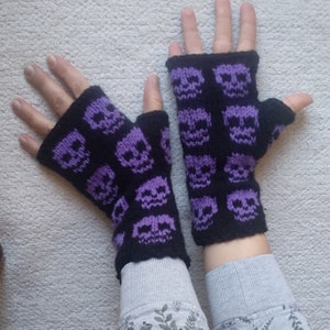 May include: A pair of black fingerless gloves with a purple skull pattern.