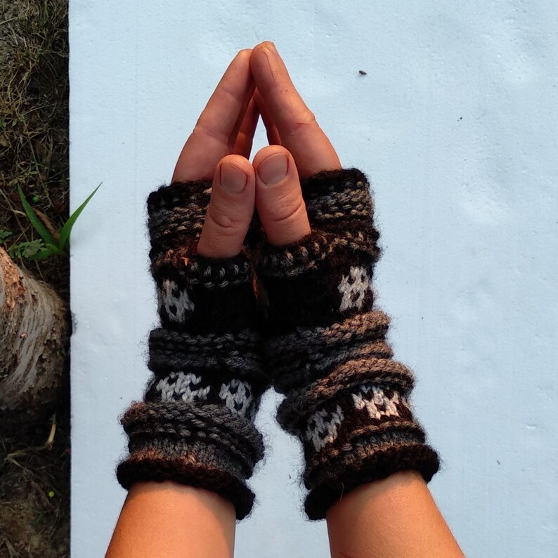May include: A pair of black and white fingerless gloves with a geometric pattern. The gloves are made of a soft, knitted fabric and have a warm, cozy feel.