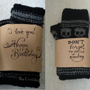 May include: A pair of black and gray knit socks wrapped in brown paper with a handwritten message that says "I love you! Happy Birthday" and "The Crookes". The other sock is wrapped in brown paper with a handwritten message that says "DON'T forget to smile Today".