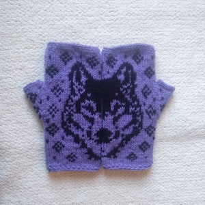 May include: A pair of fingerless gloves in a lavender color with a black wolf design. The gloves are knitted with a diamond pattern around the wolf's head. The gloves are made of a soft, warm material.