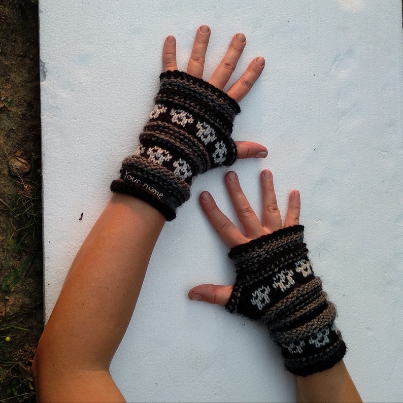 May include: A pair of fingerless gloves with a black and white geometric pattern. The gloves have the text "Your name" on one of the gloves.
