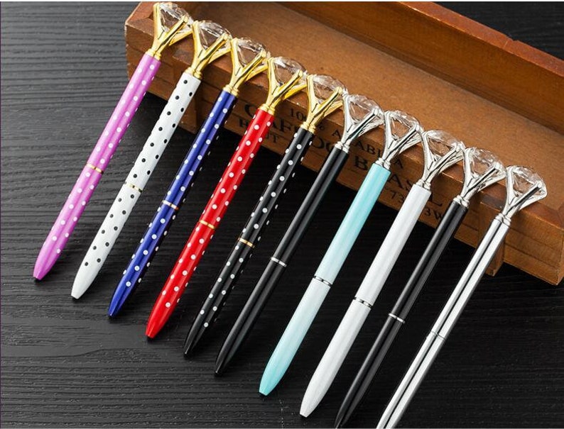May include: A set of ten pens with diamond-shaped tops. The pens have polka dot patterns in various colors, including pink, white, blue, red, and black.