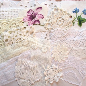 Peut inclure: Assortiment de dentelles blanches et crème, de bordures et de chutes de tissu. Les chutes de tissu comprennent un imprimé floral avec une fleur violette.
