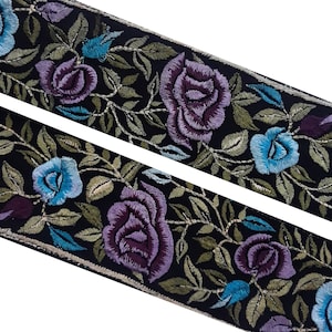 May include: Black fabric trim with embroidered floral design featuring blue and purple roses, green leaves, and gold accents.