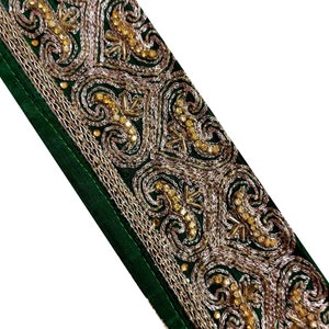 Peut inclure: Garniture en velours vert avec broderie dorée et argentée. La garniture présente un motif répété de volutes ornées et de motifs floraux.
