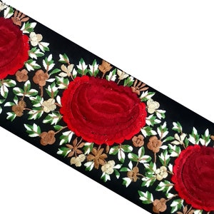 May include: Black velvet trim with red velvet roses and embroidered green leaves and white flowers.