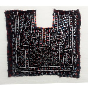 Peut inclure: Un collier en tissu noir avec un motif géométrique, orné de petits miroirs ronds et de broderies blanches. Le collier a une bordure frangée.