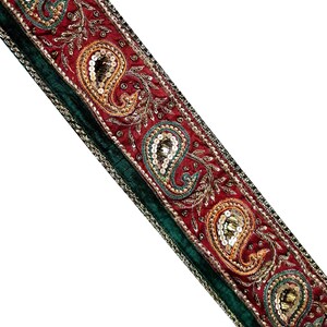 May include: Red and green fabric trim with gold and silver sequins and embroidery in a paisley pattern.