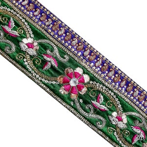 May include: Green velvet trim with embroidered floral designs, sequins, and beads. The trim features a blue and gold stripe with sequins.