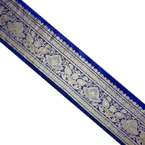 Può includere: Bordino in tessuto blu con ricamo dorato con un motivo paisley.