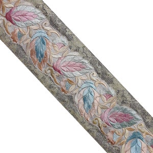May include: A beige fabric trim with a repeating pattern of embroidered leaves in shades of pink, blue, and green.