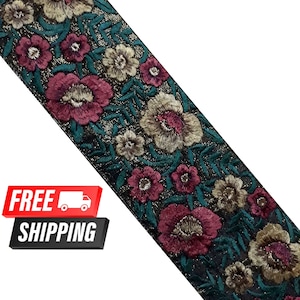 Può includere: Un bordino ricamato color turchese, nero e oro con un motivo floreale. Il bordino presenta fiori rosa, bianchi e dorati con foglie verdi.