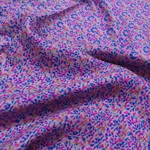 Puede incluir: Tela morada con un patrón floral en tonos de azul, rosa y marrón.