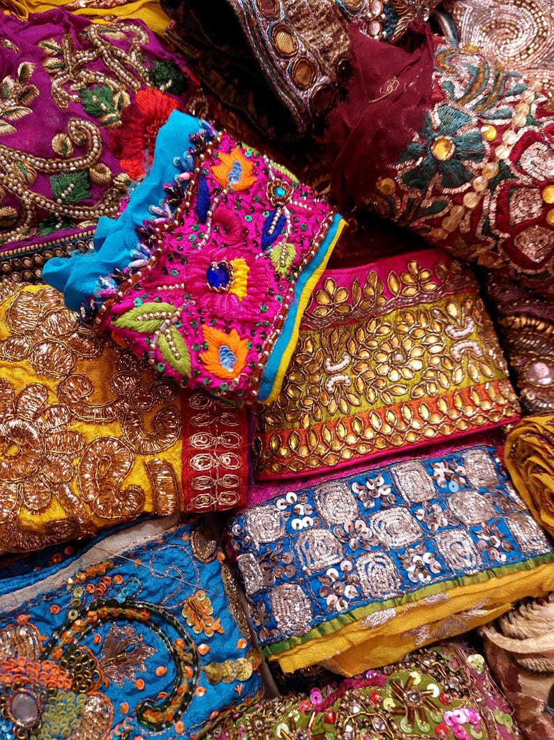 Discover a stunning assortment of vintage Indian saree trims with this wholesale lot! Each piece features rich embroidery, sequins, beads, and zari work, making it perfect for DIY projects, fashion, and home décor.
Each bag includes a minimum of 10, 15, or 25 beautifully embroidered fabric pieces, perfect for embellishments, crafts, collage, ribbons, and border trims.
This one-of-a-kind mix of handcrafted trims is perfect for crafters, designers, and creative minds.