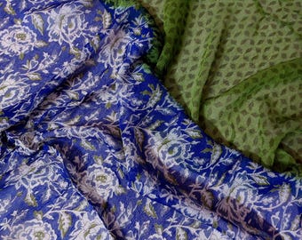 May include: Blue and white floral fabric with a green floral pattern on top. The fabric is sheer and has a delicate texture.