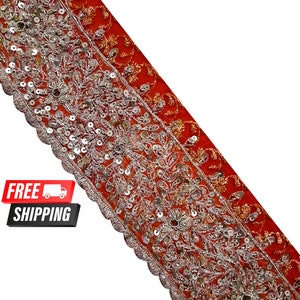 May include: Red and silver embroidered trim with sequins. The trim has a scalloped edge and is perfect for adding a touch of elegance to any project.