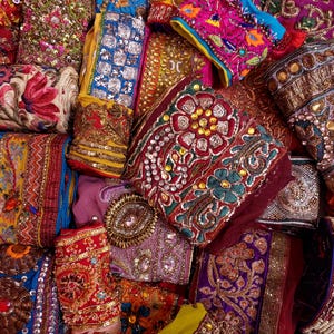 Discover a stunning assortment of vintage Indian saree trims with this wholesale lot! Each piece features rich embroidery, sequins, beads, and zari work, making it perfect for DIY projects, fashion, and home décor.
Each bag includes a minimum of 10, 15, or 25 beautifully embroidered fabric pieces, perfect for embellishments, crafts, collage, ribbons, and border trims.
This one-of-a-kind mix of handcrafted trims is perfect for crafters, designers, and creative minds.