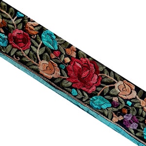 Peut inclure: Garniture en tissu noir avec un motif floral brodé comprenant des fleurs rouges, orange, bleues et vertes.