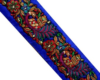 Pode incluir: Bordado de veludo azul com desenhos florais e de pavão bordados em cores.