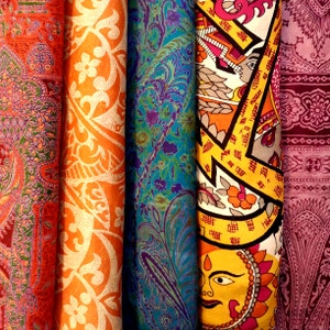 Peut inclure: Quatre échantillons de tissu différents avec des motifs paisley complexes. Les échantillons sont dans des tons de rouge, orange, bleu et violet.