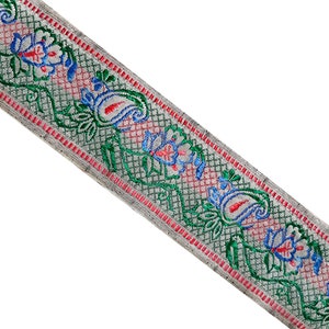 Puede incluir: Un ribete blanco con un patrón floral verde, azul y rojo. El ribete tiene un diseño de cachemira y un patrón de cuadrícula.