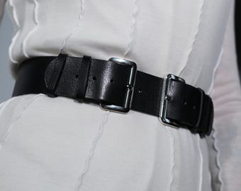 May include: A black leather belt with silver buckle and double straps.