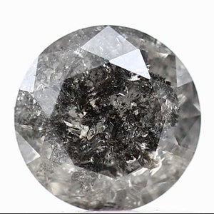 May include: A round, faceted, black diamond with inclusions. The diamond is cut in a round brilliant style.