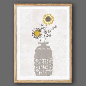 May include: A gray vase with a textured pattern holds a bouquet of yellow and gray flowers. The flowers have a simple, geometric design.