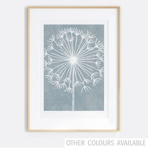 May include: A framed print of a white dandelion on a blue background. The dandelion is stylized and has a simple, minimalist design.