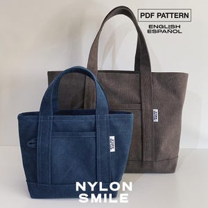 Puede incluir: Dos bolsos tote en azul oscuro y gris oscuro, cada uno con dos asas superiores, un bolsillo frontal y una pequeña etiqueta blanca con el texto NYLON SMILE. La imagen incluye el texto PDF PATTERN ENGLISH ESPAÑOL y NYLON SMILE abajo.