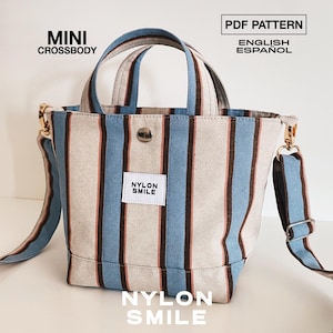 May include: A mini crossbody bag featuring vertical stripes in light blue, dark brown, and off-white. The bag has two top handles, a detachable shoulder strap with metal hardware, and a white label reading NYLON SMILE. Text reads MINI CROSSBODY, PDF PATTERN, ENGLISH, ESPA&Ntilde;OL, and NYLON SMILE.