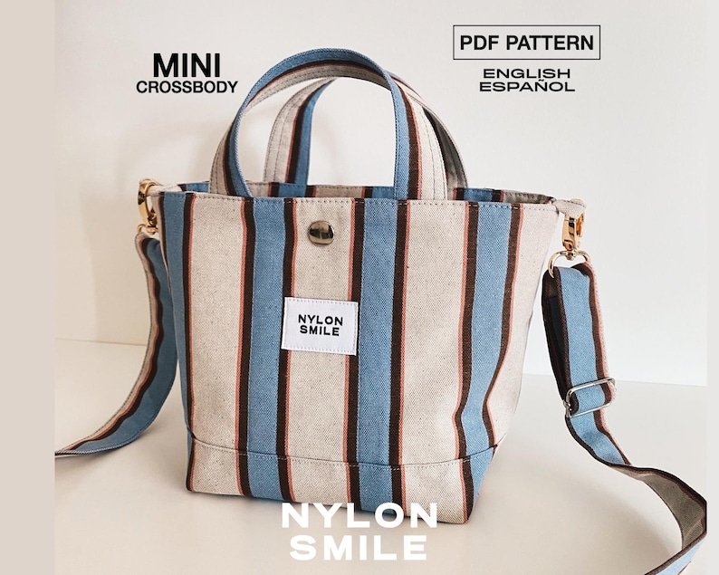 May include: A mini crossbody bag featuring vertical stripes in light blue, dark brown, and off-white. The bag has two top handles, a detachable shoulder strap with metal hardware, and a white label reading NYLON SMILE. Text reads MINI CROSSBODY, PDF PATTERN, ENGLISH, ESPA&Ntilde;OL, and NYLON SMILE.