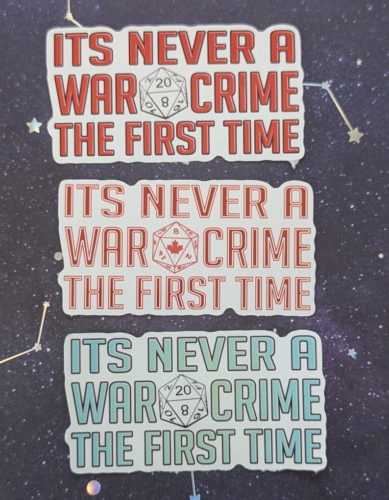 K&ouml;nnte beinhalten: Drei wei&szlig;e Aufkleber mit rotem, wei&szlig;em und blauem Text und einer schwarzen und wei&szlig;en W&uuml;rfelgrafik. Der Text auf den Aufklebern lautet "ITS NEVER A WAR CRIME THE FIRST TIME".