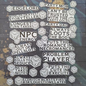 Puede incluir: Una colección de pegatinas blancas con texto negro y un gráfico de dados en blanco y negro. Las pegatinas presentan frases como "Edgelord", "Mamá de la fiesta", "El mejor narrador del mundo", "El que más tarda en su turno", "Energía de PNJ", "Siempre sin espacios de hechizos", "Siempre tira para seducir", "Nunca toma notas", "No se puede confiar con el oro de la fiesta", "Papá de la fiesta", "Siempre saquea el cuerpo", "Pone la romance en el nigromante", "Jugador problemático", "Pone lo lindo en la ejecución", "Explosiones de Eldritch primero, preguntas después".