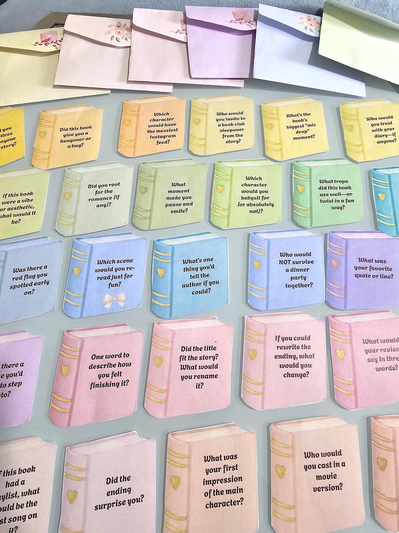 Peut inclure: Cartes en forme de livre de couleurs pastel vari&eacute;es avec des questions sur les livres. Chaque carte contient une question diff&eacute;rente, comme &laquo;&nbsp;Ce livre vous a-t-il donn&eacute; une gueule de bois ou un c&acirc;lin&nbsp;?&nbsp;&raquo; et &laquo;&nbsp;Quelle a &eacute;t&eacute; votre premi&egrave;re impression du personnage principal&nbsp;?&nbsp;&raquo;