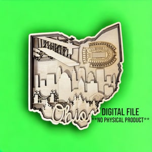 Puede incluir: Un diseño de madera cortado con láser del estado de Ohio con un horizonte de Cleveland, un estadio de fútbol y un avión. La palabra "Ohio" está escrita en una fuente decorativa en la parte inferior del diseño. El texto "ARCHIVO DIGITAL **SIN PRODUCTO FÍSICO**" está escrito en la parte inferior de la imagen.