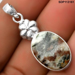 Op de afbeelding: Zilveren hanger met een ovaalvormige steen met grijze, bruine en witte patronen. De hanger heeft een bloemvormig accent en een lus voor een ketting. De tekst "SDP113161" is zichtbaar.