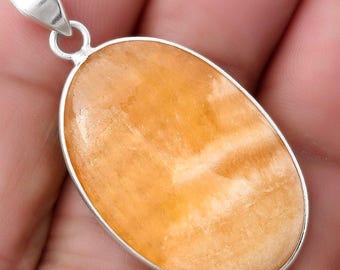 May include: An oval-shaped pendant featuring a smooth, polished orange and white banded gemstone set in a silver-toned metal frame with a triangular bail at the top. The text SDP120188 is visible in the upper right corner of the image.